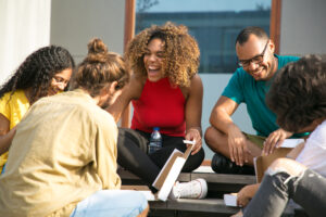 Amigos rindo uns com os outros no trabalho para ilustrar o artigo O que é voluntariado e como voluntariar em um hostel