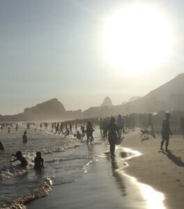 Foto de uma praia do rio de janeiro em um dia ensolarado e com várias pessoas se refrescando na água para ilustrar o artigo melhores praias do rio de janeiro