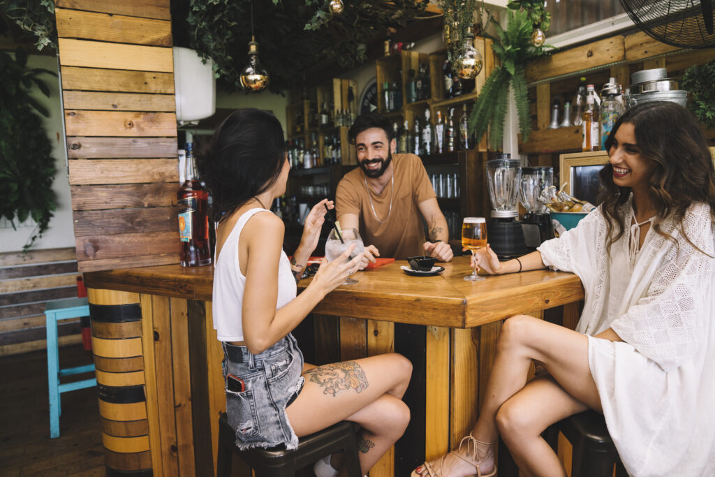 Amigos conversando, comendo e bebendo em um restaurante juntos para ilustrar o artigo Restaurantes em Botafogo: as melhores opções de onde comer